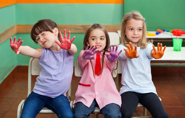 Menina com amigos mostrando palmas coloridas — Fotografia de Stock