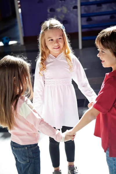 Enfants jouant tout en tenant les mains dans la maternelle — Photo