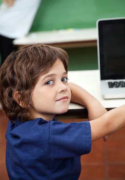 Jongen met laptop op Bureau in klas — Stockfoto