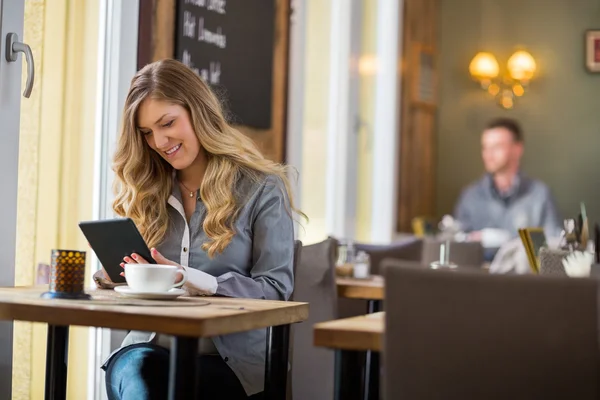 Vrouw met behulp van digitale Tablet PC aan tafel — Stockfoto