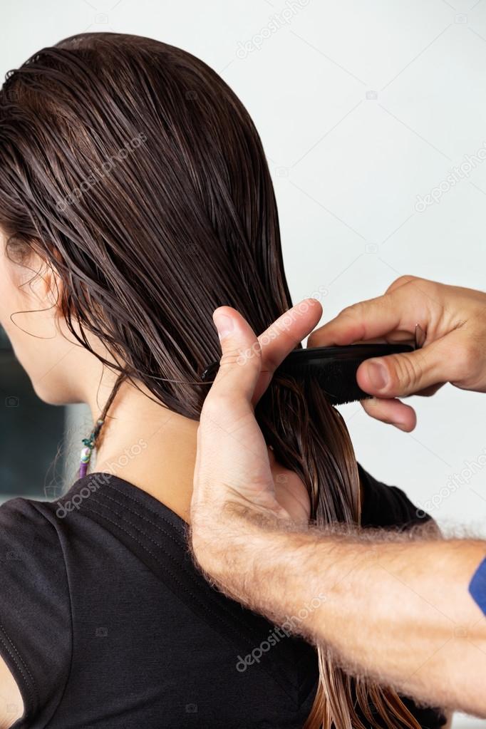 Hairdresser Combing Client's Wet Hair