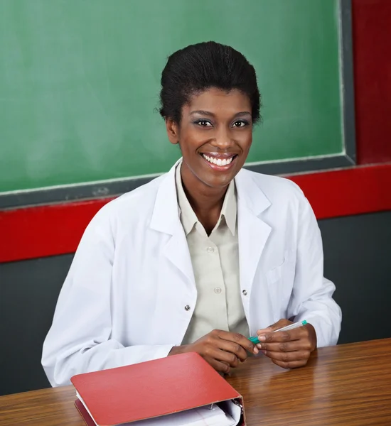 Confident Female Professor Sitting At Desk — Stock Photo, Image