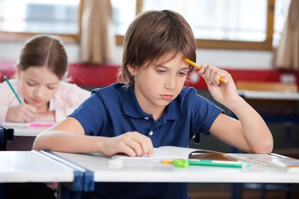 Thoughtful Schoolboy Sitting At Desk — Stock Photo, Image