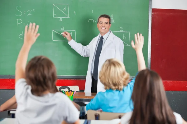 Leraar lesgeven terwijl studenten verhogen handen — Stockfoto