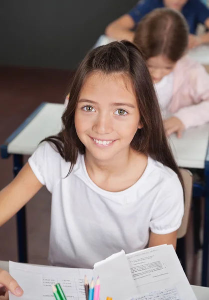 Schoolmeisje zit aan Bureau in klas — Stockfoto