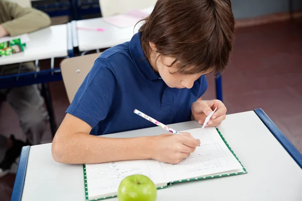 Schooljongen kopiëren van cheatsheet tijdens onderzoek — Stockfoto