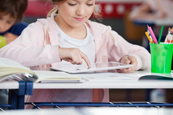 Schoolgirl Using Tablet At Desk Stock Image