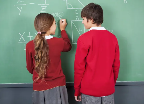 Students Looking At Each Other While Writing On Board — Stock Photo, Image