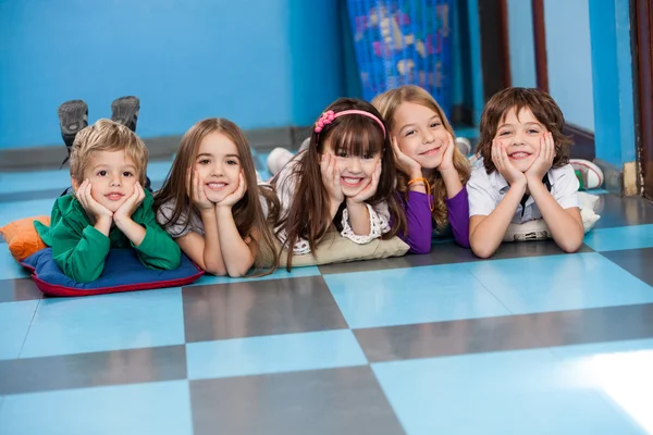 Enfants allongés dans une rangée sur le sol — Photo