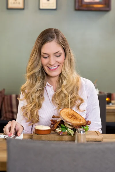 Junge Frau schaut sich Burger an — Stockfoto