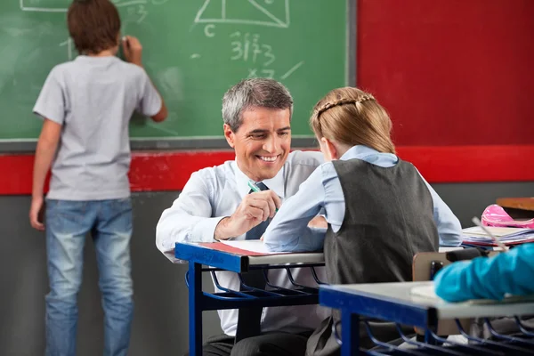 Professora assistente de estudante na mesa — Fotografia de Stock