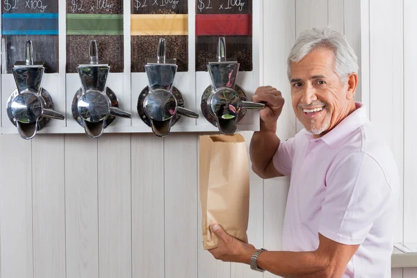 Senior kauft Kaffeebohnen am Automaten — Stockfoto