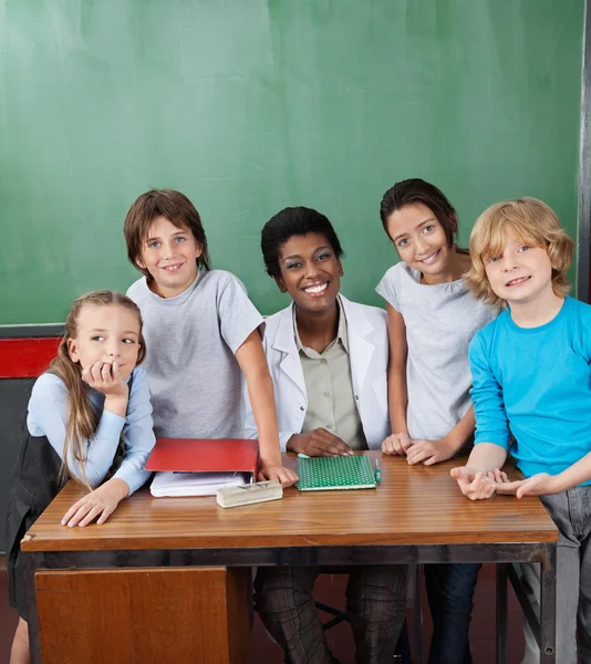 Happy Female Professor With Students At Desk — Stock Photo, Image
