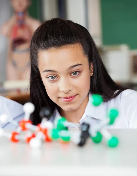 Vacker tonårig skolflicka undersöker molekylära struktur — Stockfoto