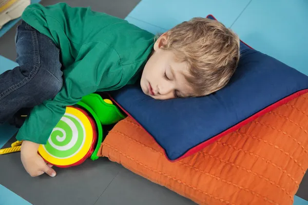 Chlapec spí s hračkou ve školce — Stock fotografie