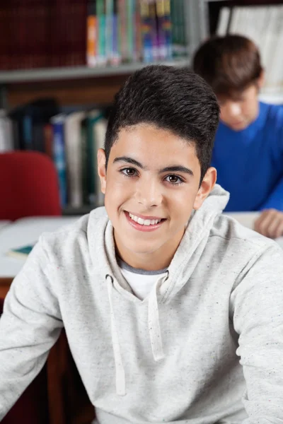 Teenage Schoolboy Sitting In Library Stock Picture