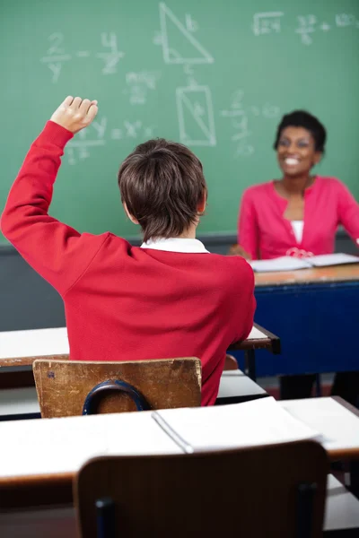 Studente adolescente alzare la mano alla scrivania — Foto Stock