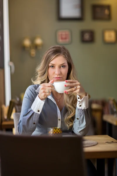 Mujer joven bebiendo café en la cafetería — Foto de Stock