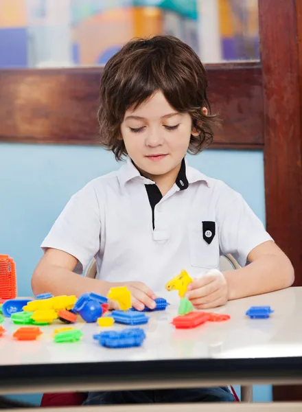 Menino brincando com blocos na sala de aula — Fotografia de Stock