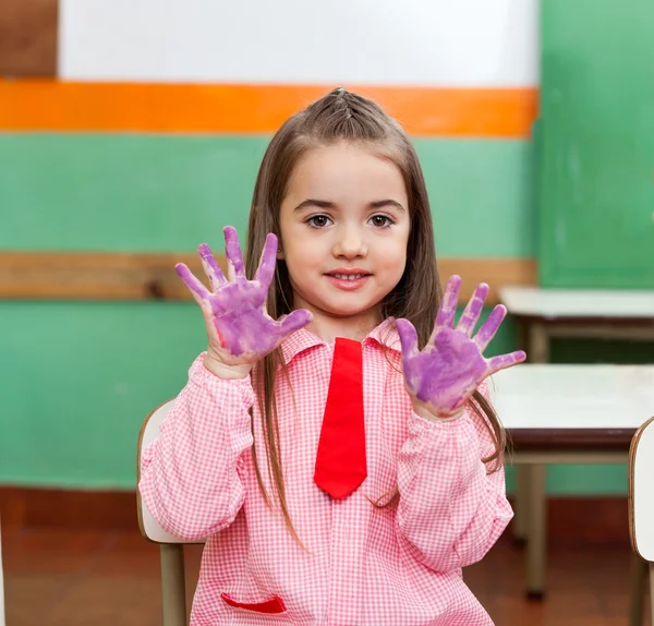 Menina mostrando palmas coloridas com amigos no fundo — Fotografia de Stock