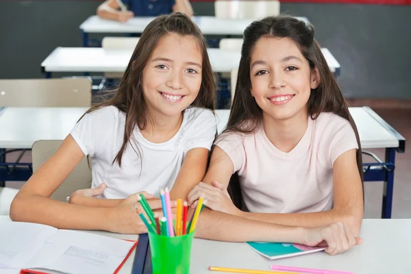 Colegialas sentadas en el escritorio en el aula —  Fotos de Stock