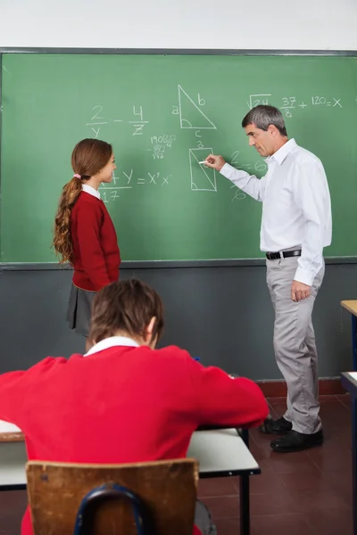 Professor do sexo masculino que ensina geometria para menina na sala de aula — Fotografia de Stock