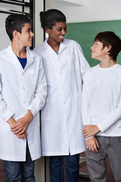 Öğretmen ve genç erkekler birlikte fen laboratuarında ayakta — Stok fotoğraf