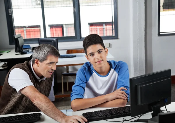 Adolescente Schoolboy com professor usando computador no laboratório — Fotografia de Stock