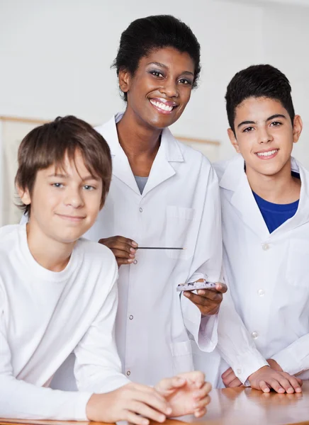 Retrato de profesora con estudiantes masculinos experimentando — Foto de Stock