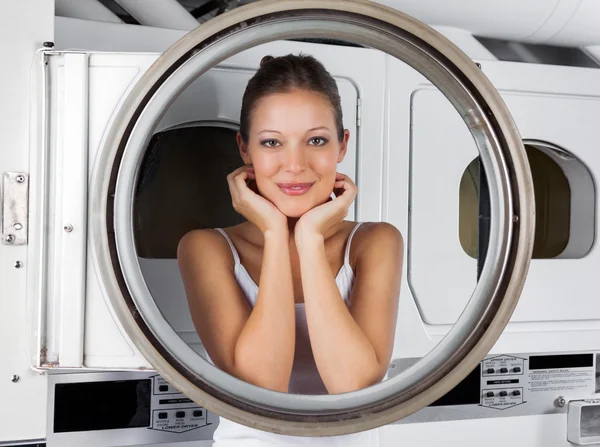 Mulher inclinada na porta da máquina de lavar — Fotografia de Stock