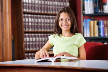 ile kitap kütüphane masada oturan kız öğrenci