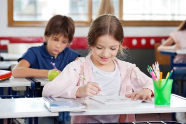 liseli kızlar sınıfta çizerken gülümseyen
