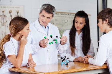 öğretmen öğrencilerle masa moleküler atomları analiz