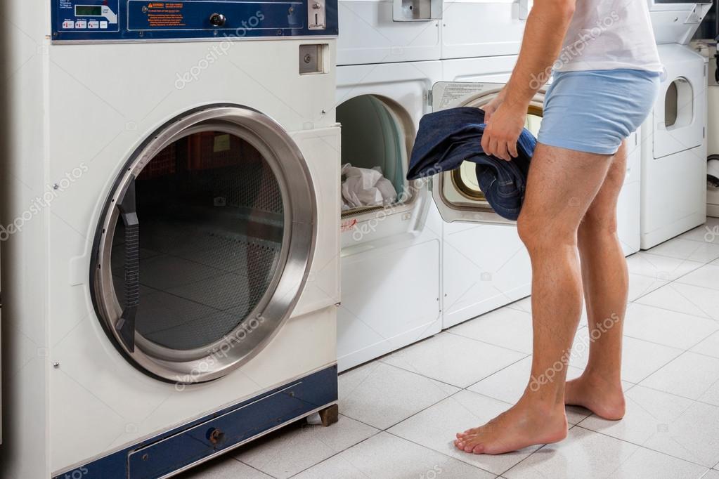 Man Putting Clothes In Washing Machine — Stock Photo © SimpleFoto 27801913