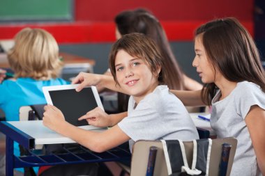 Masa başında dijital tablet kullanan kız çocuk