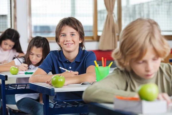 Sınıf üst üste masa başında oturan bir okul çocuğu — Stok fotoğraf
