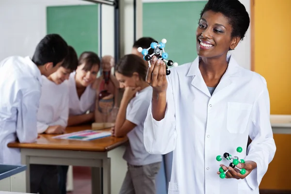 Insegnante femminile guardando struttura molecolare — Foto Stock