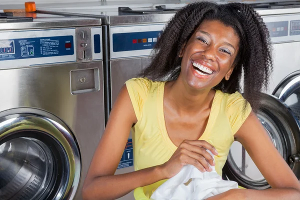 Vrolijke vrouw met kleren in Wasserij — Stockfoto