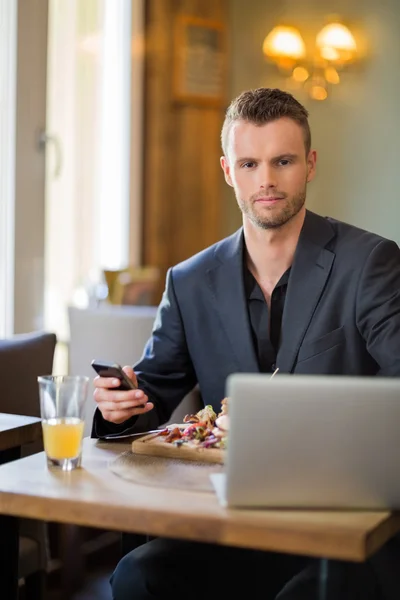 Uomo d'affari con cellulare e computer portatile con cibo — Foto Stock