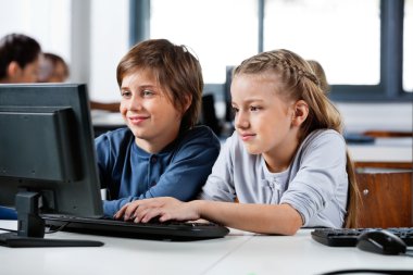 Boy And Girl Using Desktop Pc In School Computer Lab clipart