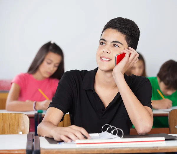 Homme étudiant utilisant un téléphone portable dans la salle de classe — Photo