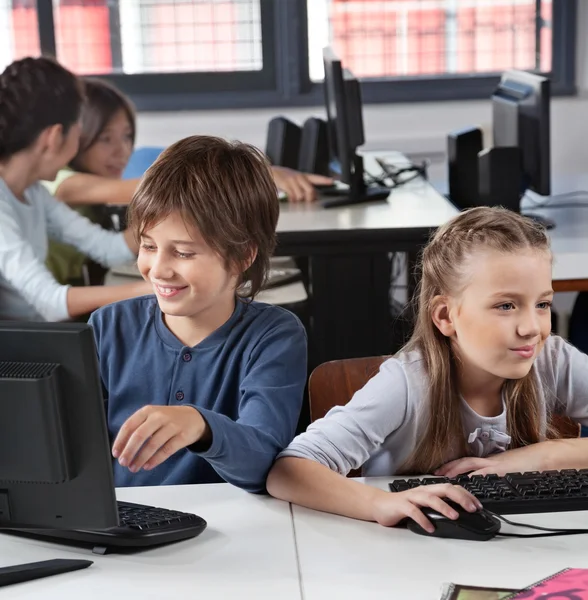 Skolbarn använder dator på skrivbordet — Stockfoto