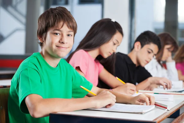 Dospívající chlapec s přáteli studia na stůl — Stock fotografie