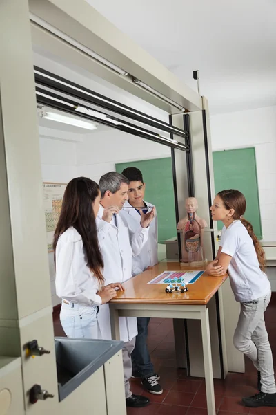 Δάσκαλος πειραματίζεται ενώ φοιτητές που κοιτάζει — Stock fotografie
