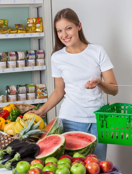 Женщина делает покупки фруктов и овощей в магазине — стоковое фото