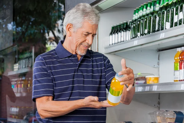 Senior male kunden köpa juice flaska — Stockfoto