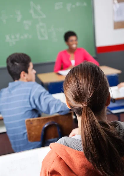 Adolescente écolière avec camarade de classe et professeur — Photo