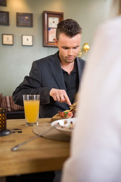 Zakenman met voedsel met vrouwelijke collega — Stockfoto