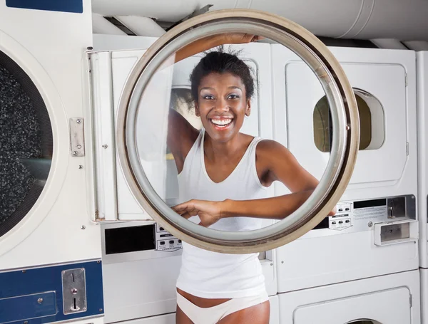 Mulher olhando através da porta da máquina de lavar — Fotografia de Stock