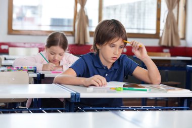 düşünceli çocuk masa başında oturan